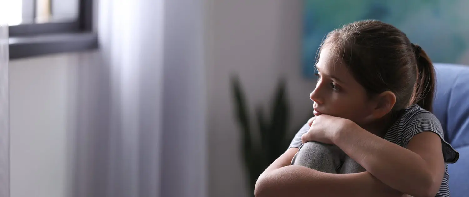 Depression Counselling Byron Shire - Depressed girl sitting on lounge